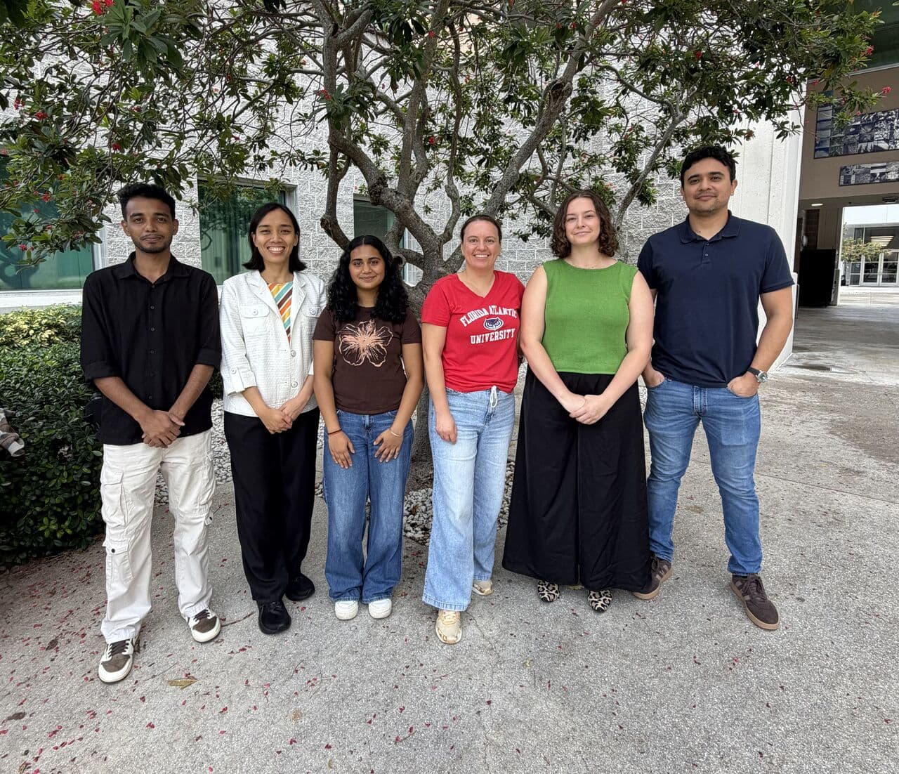 Six Transform Lab members standing in a line outside an FAU building for the Fall 2026 lab group photo